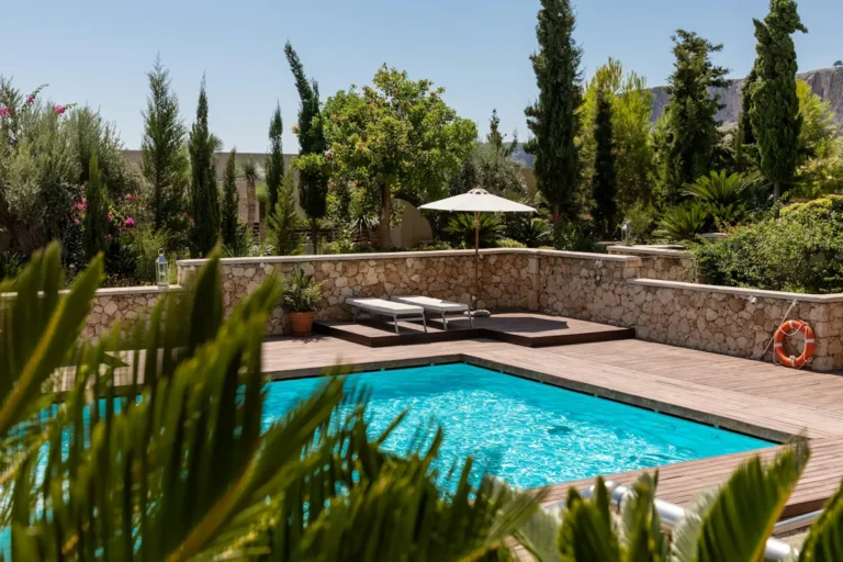 Custom pool with a natural stone wall and lush garden in South Florida